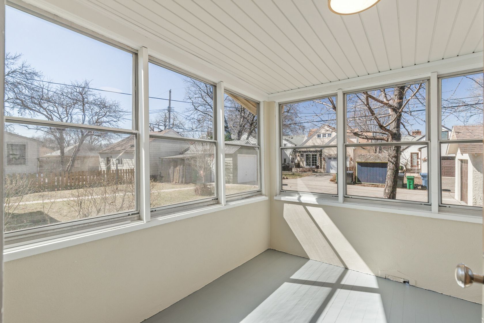 Sun porch with original beadboard ceiling and panoramic windows