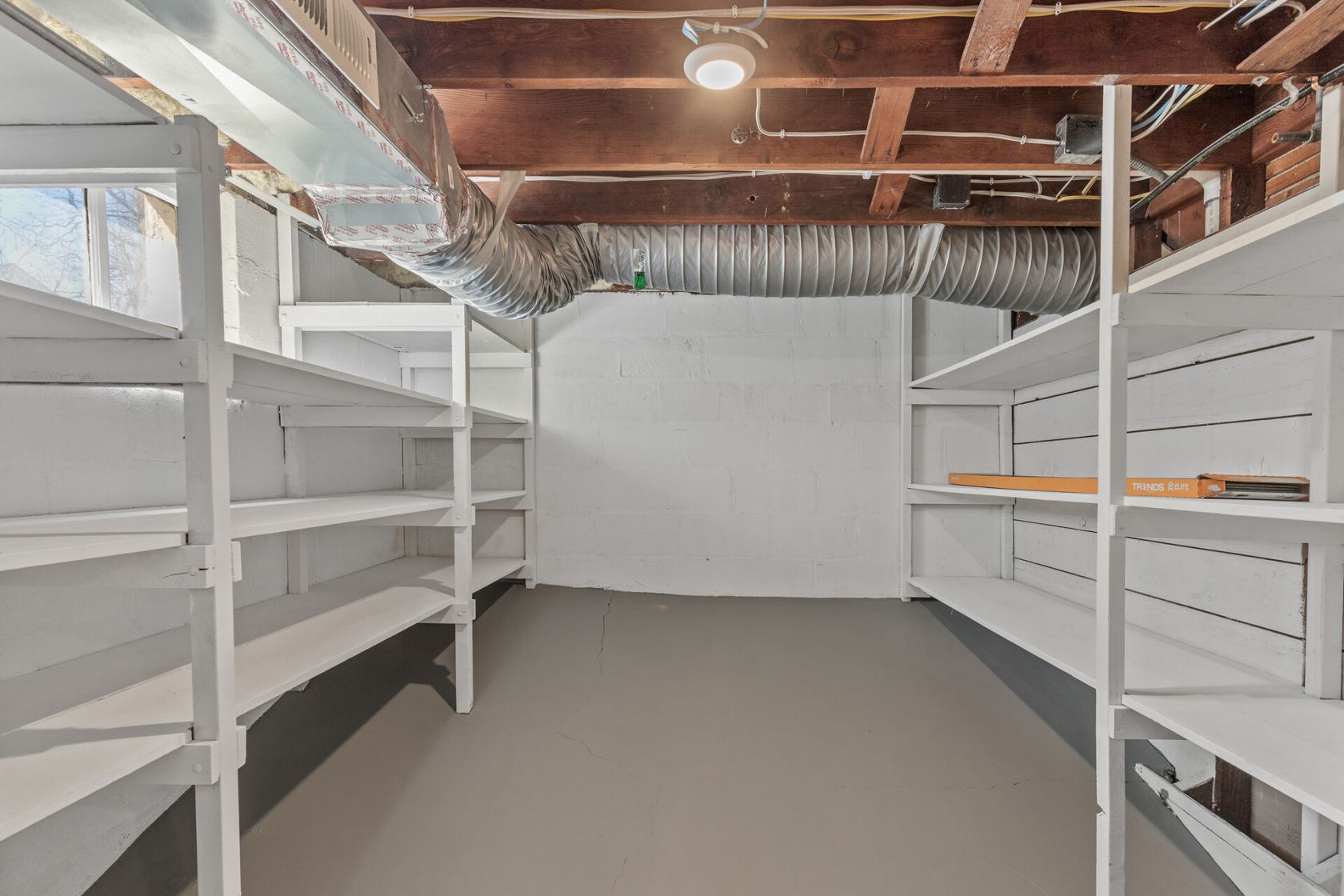 Refinished storage room with painted shelving and sealed concrete floor