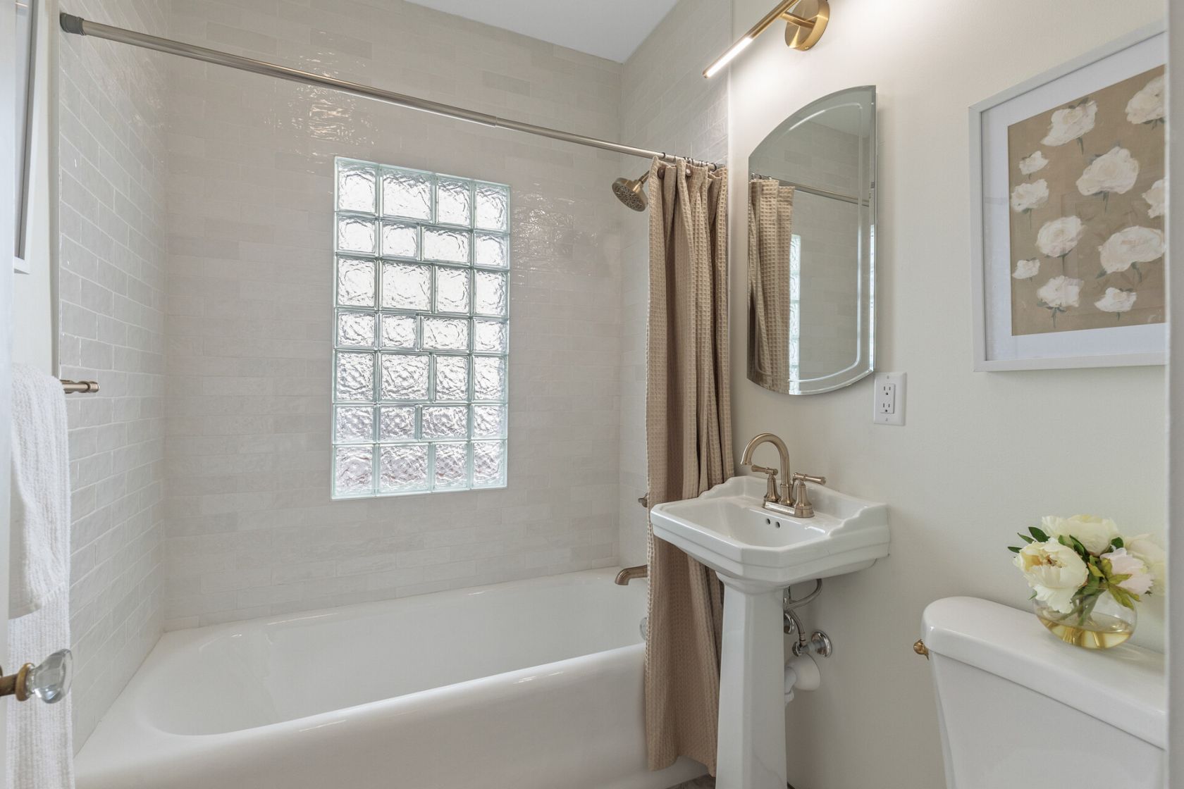 Updated bath with subway tile, pedestal sink, and glass block window