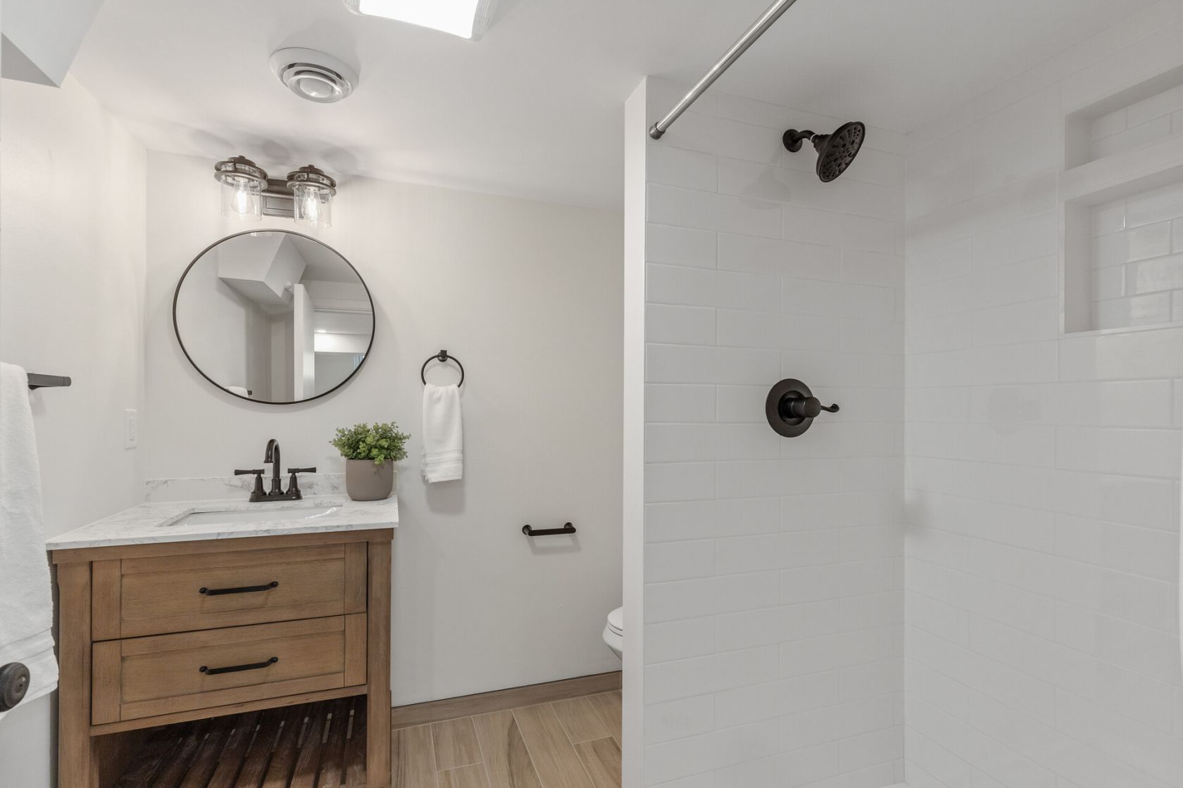 Lower level three-quarter bath with walk-in shower and oak vanity